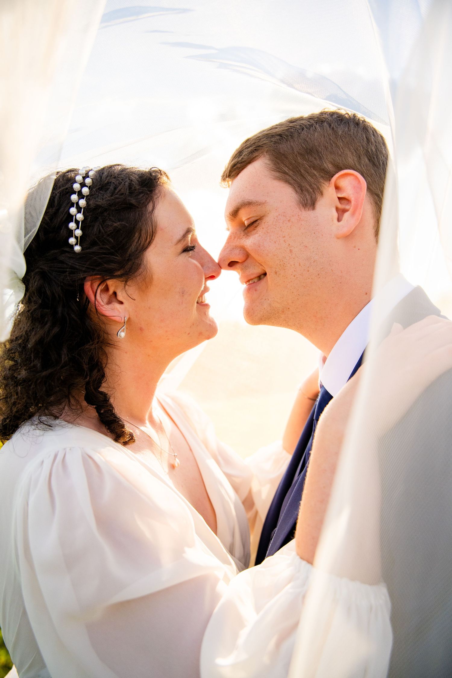 Romantic sunset wedding photos on a rustic dirt path through a grassy field.