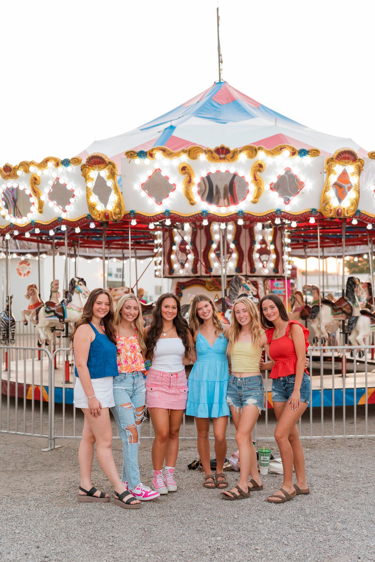 A colorful carousel provides a festive backdrop for a group photo at a summer fair or carnival.