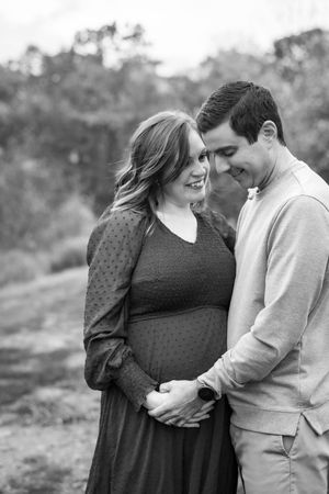 A couple shares an intimate black and white moment during their pregnancy photoshoot.