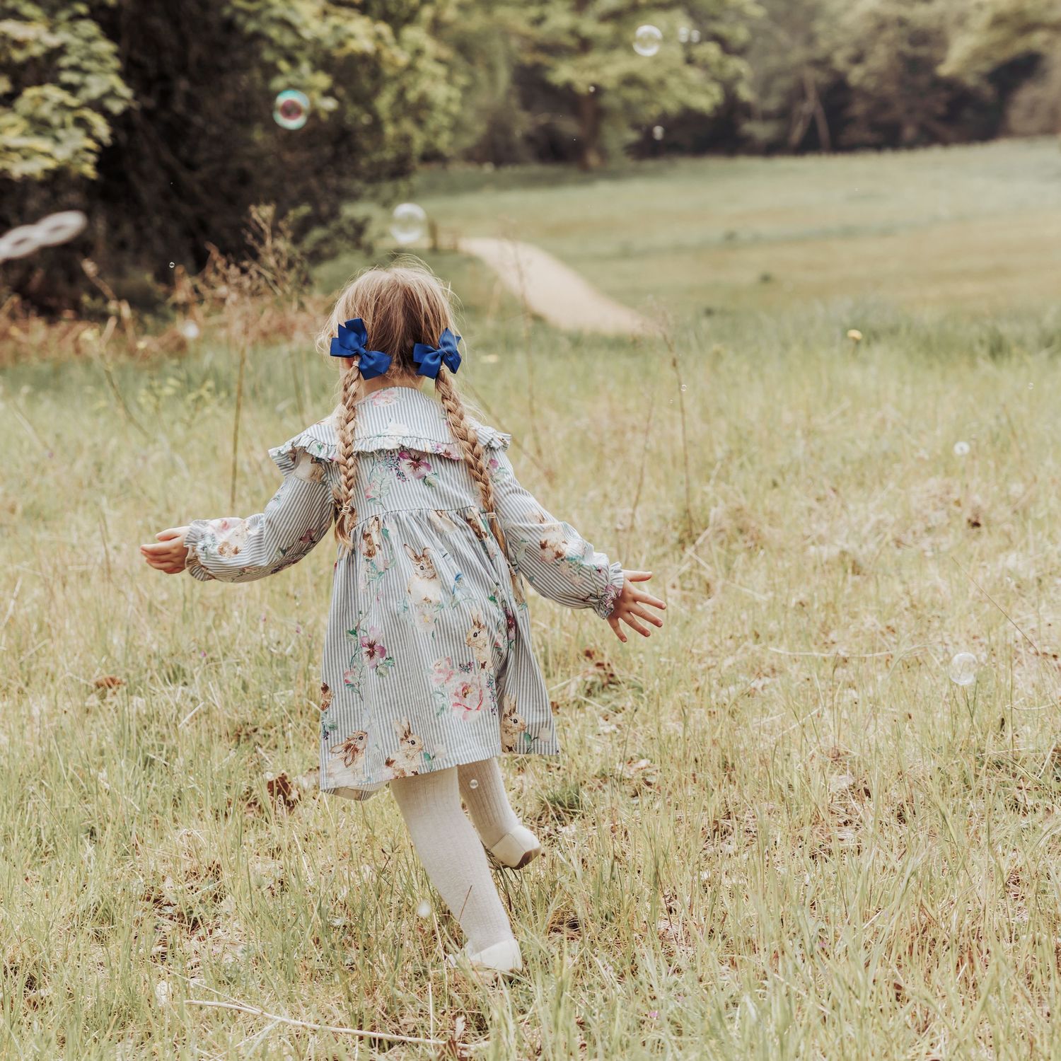 Child-led photoshoot capturing a young child running freely through long grass, celebrating natural childhood movement.