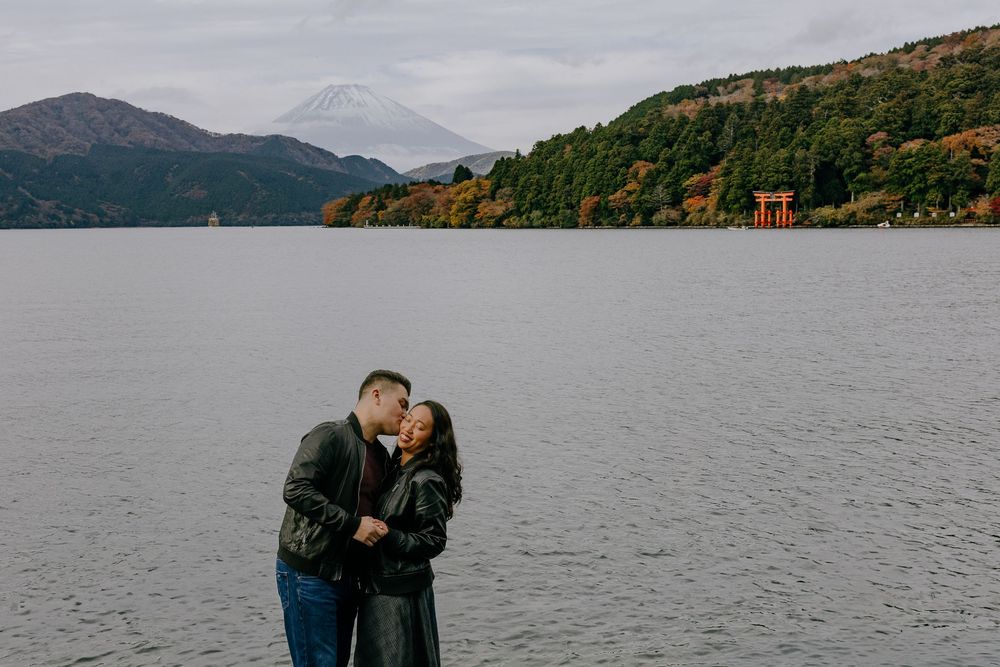 Scenic mountain landscape with lake views and autumn foliage in Hakone, Japan featuring a red torii gate.