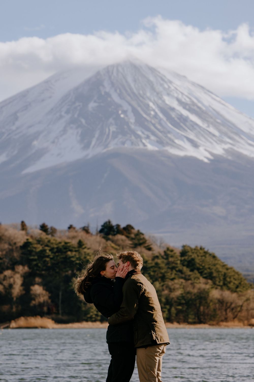 A scenic view of Mount Fuji with its snow-capped peak rising above Lake Kawaguchiko in Japan.
