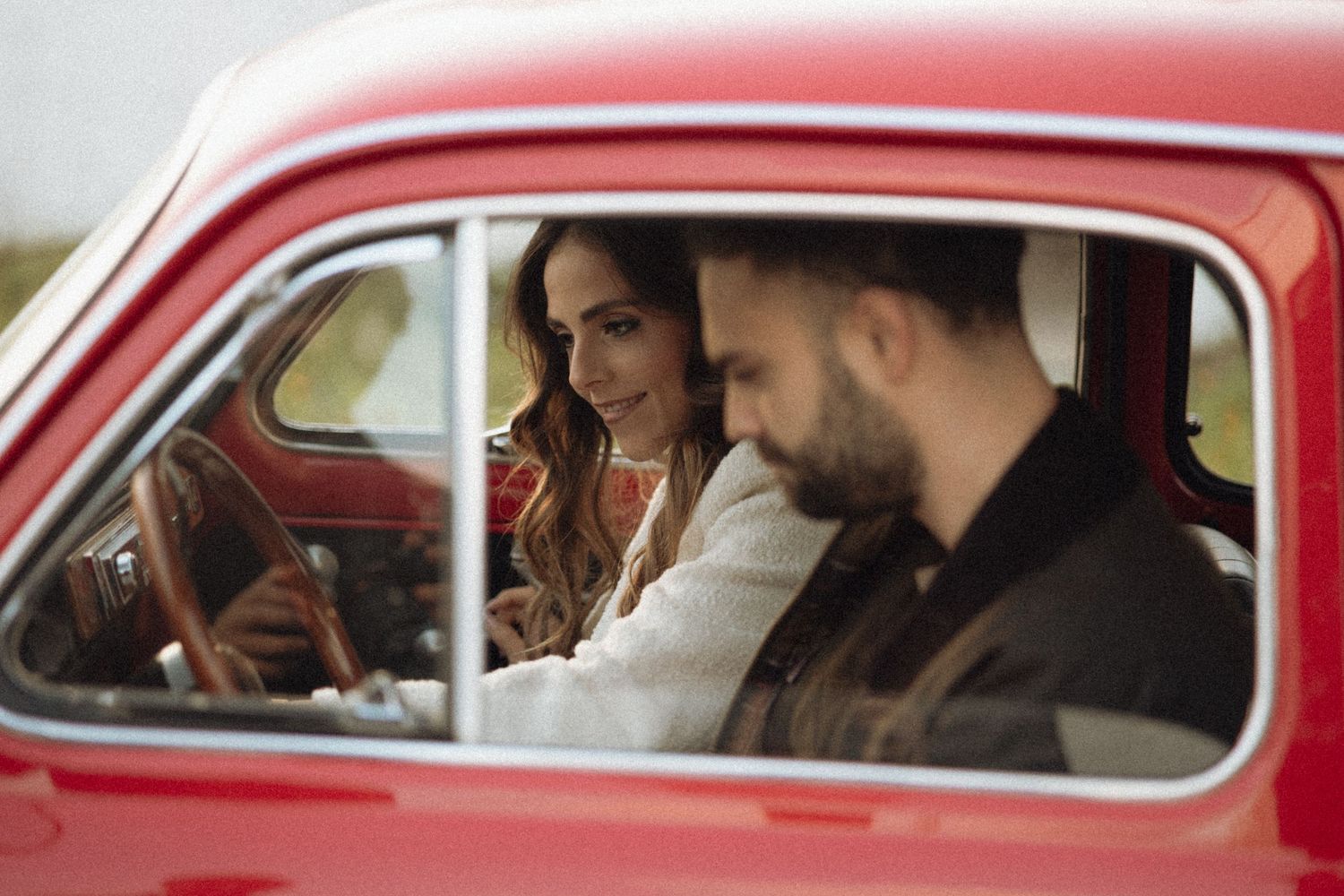 A montage of people sitting in a vintage red car shown from different angles and perspectives.