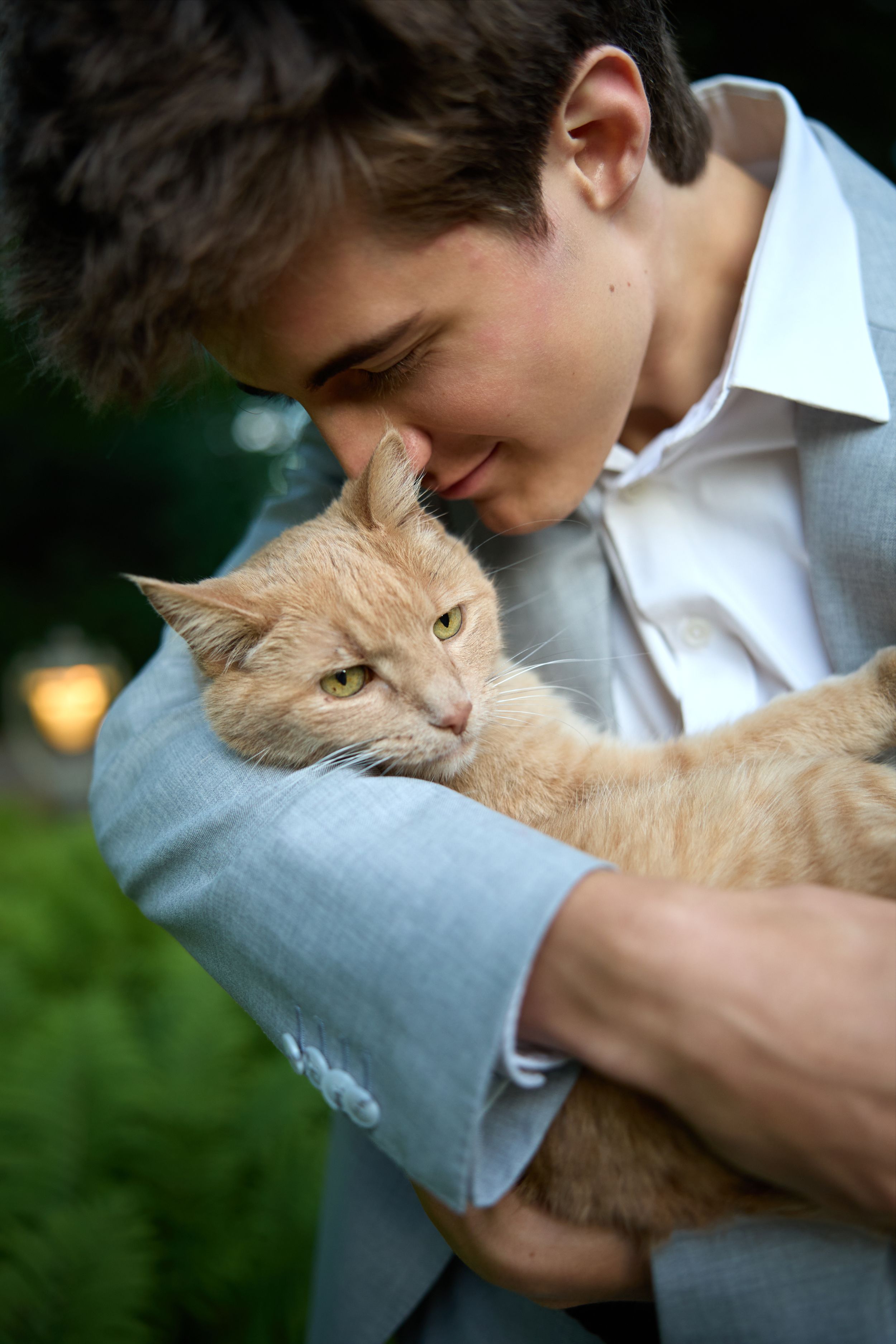 A man in Northeast Wisconsin holds his cat for a pet portrait outside tucked into his arms.