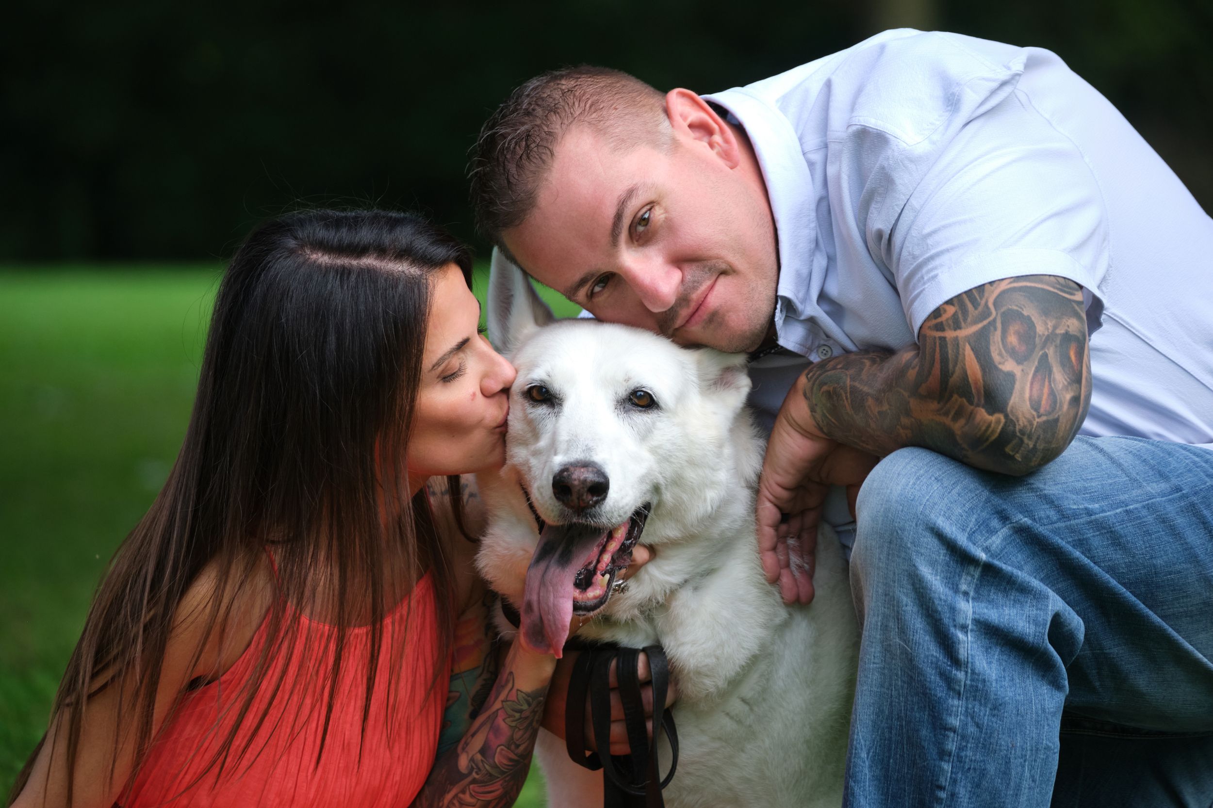 A couple poses with their white dog for an outdoor portrait photography