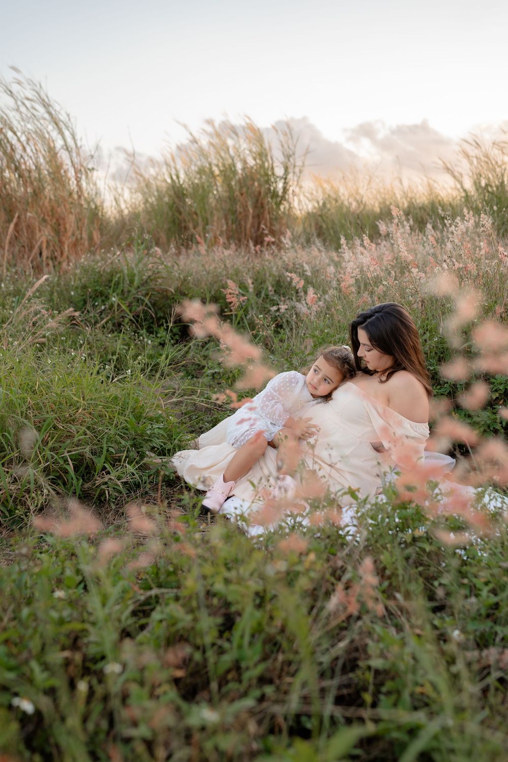 Ethereal portrait session in a wildflower meadow with soft natural lighting and white lace dress.
