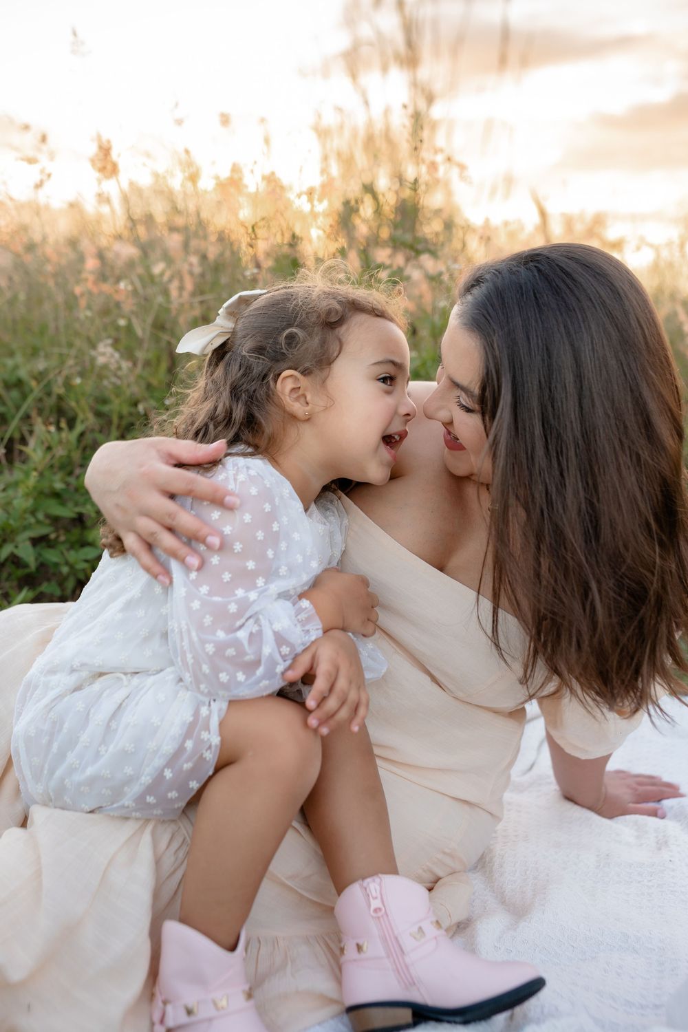 Sweet embraces shared between family members in a field during golden hour.