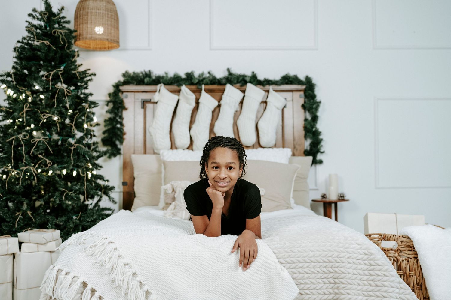 A winter scene with decorated Christmas trees, white furniture, and cozy holiday decor against a light backdrop.
