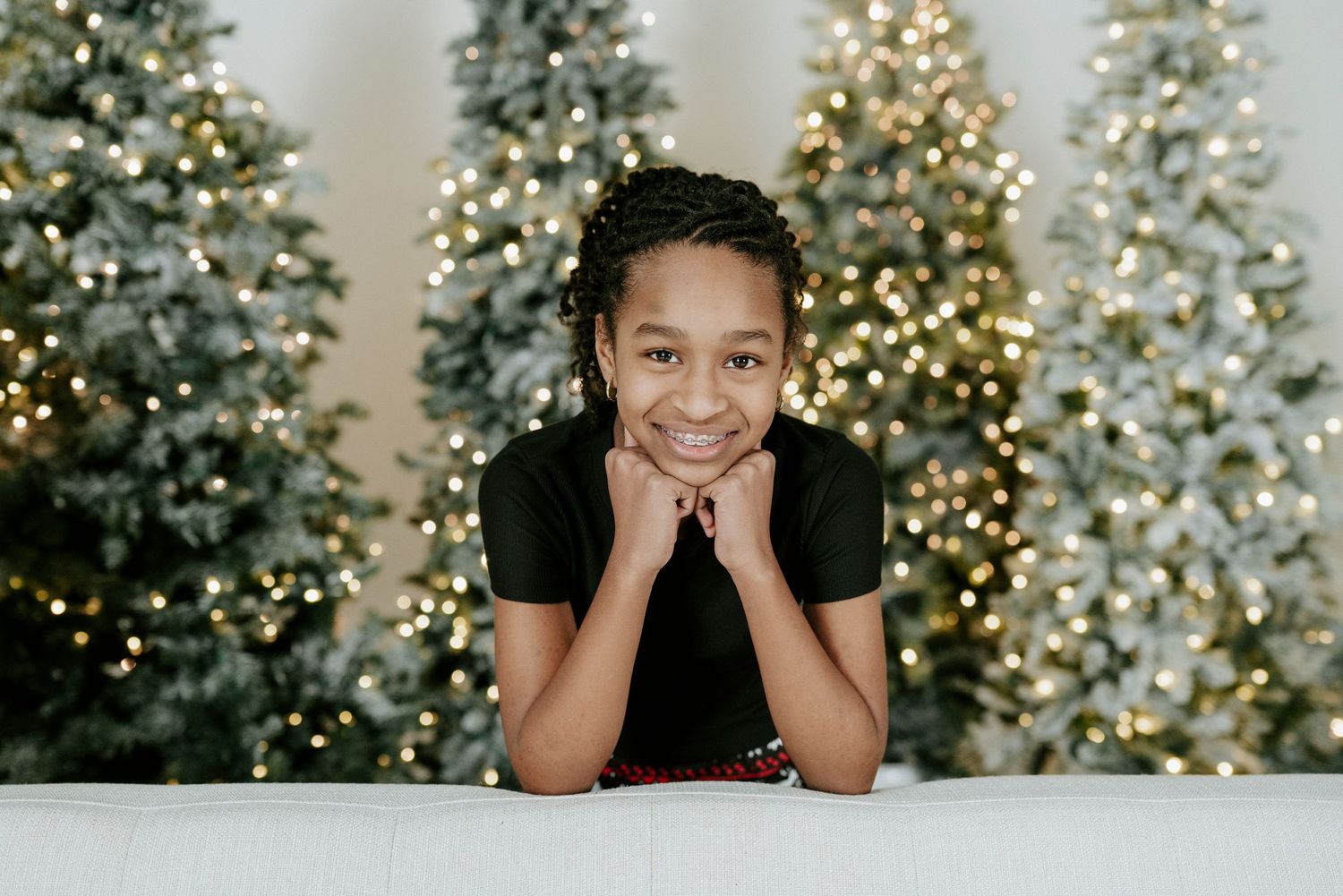 A series of holiday photos showing joyful expressions against the backdrop of sparkling Christmas trees and lights.