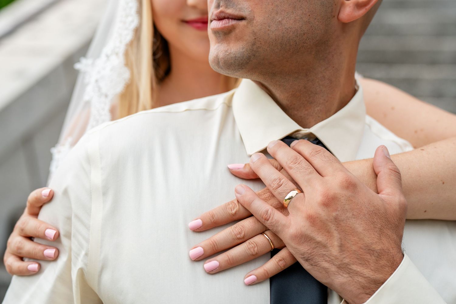 Couple in formal wedding attire sharing an intimate moment together in an elegant indoor setting.