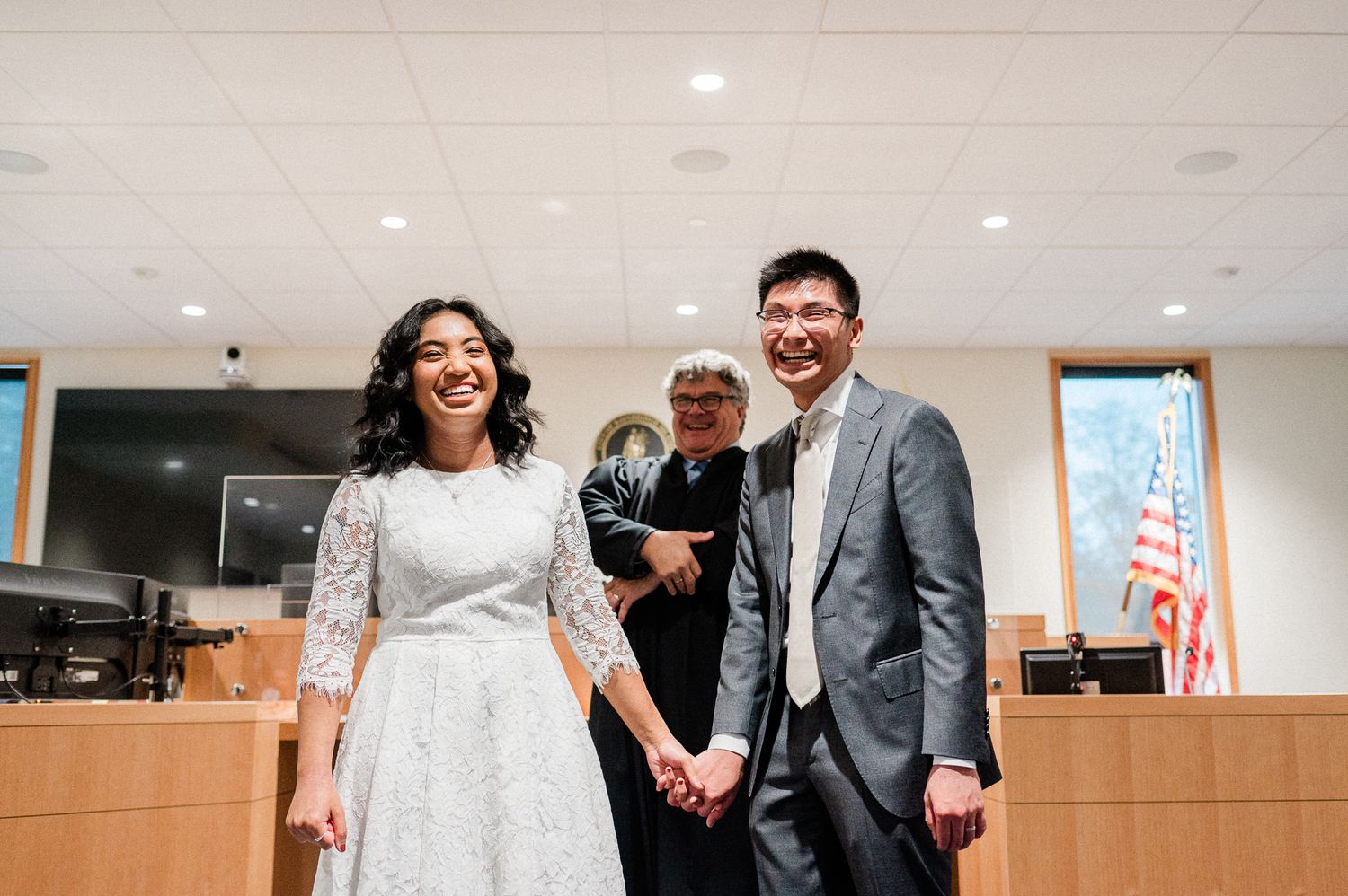 bride and groom in courthouse laughing once judge announces them officially married