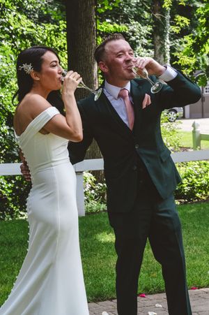 Wedding couple shares a playful moment during their celebration in a garden setting.