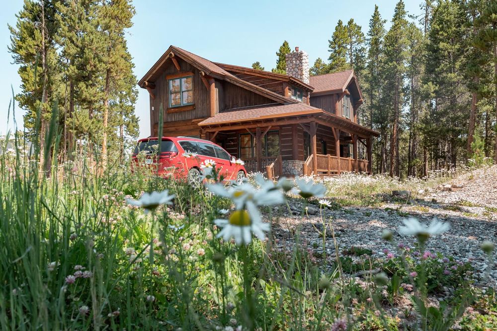 Mountain cabin nestled among pine trees with scenic landscape views.