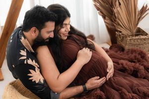 Couple sharing an intimate moment during studio maternity photoshoot, capturing emotional bonding before birth in Hyderabad