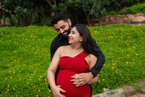 Outdoor couple maternity photoshoot capturing pregnancy bonding and joyful connection in a natural garden setting in Hyderabad