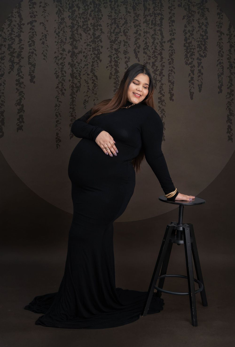 Pregnant woman posing in black gown during studio maternity photoshoot in Hyderabad