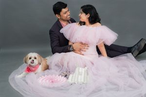 Couple maternity photoshoot with pet dog in studio, expecting parents posing together in Hyderabad