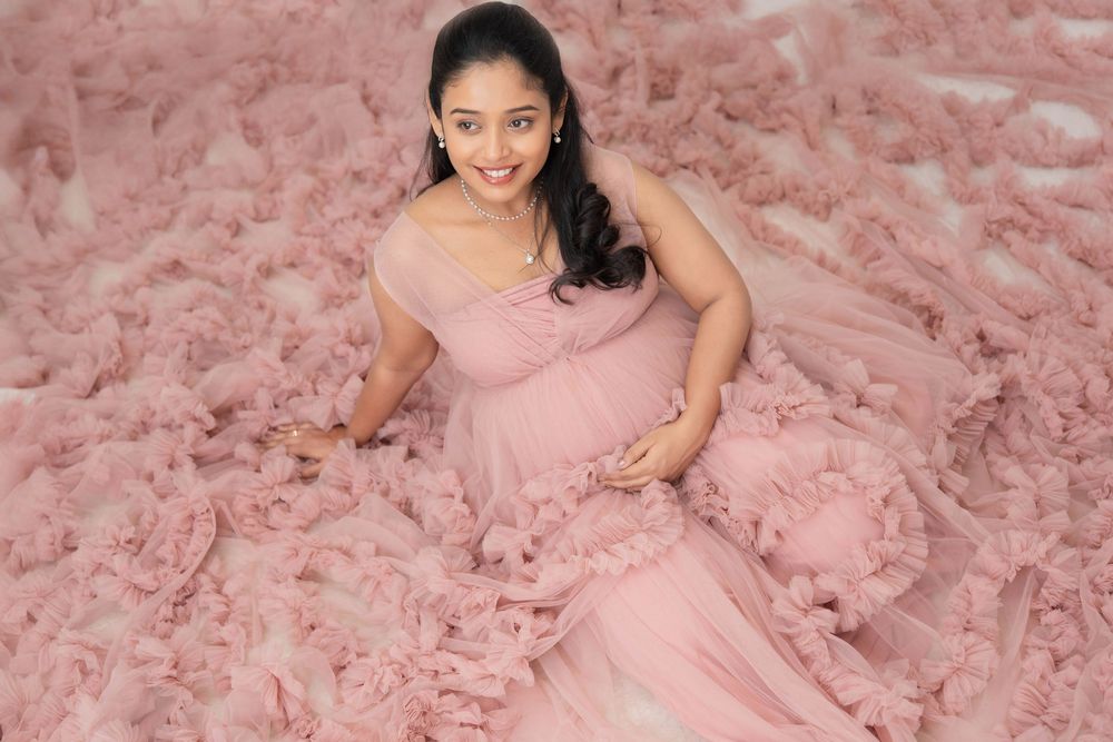 Pregnant woman wearing pink gown during studio maternity photoshoot in Hyderabad