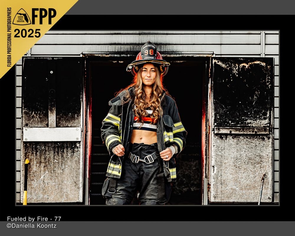 A firefighter poses in full gear against a weathered building exterior.