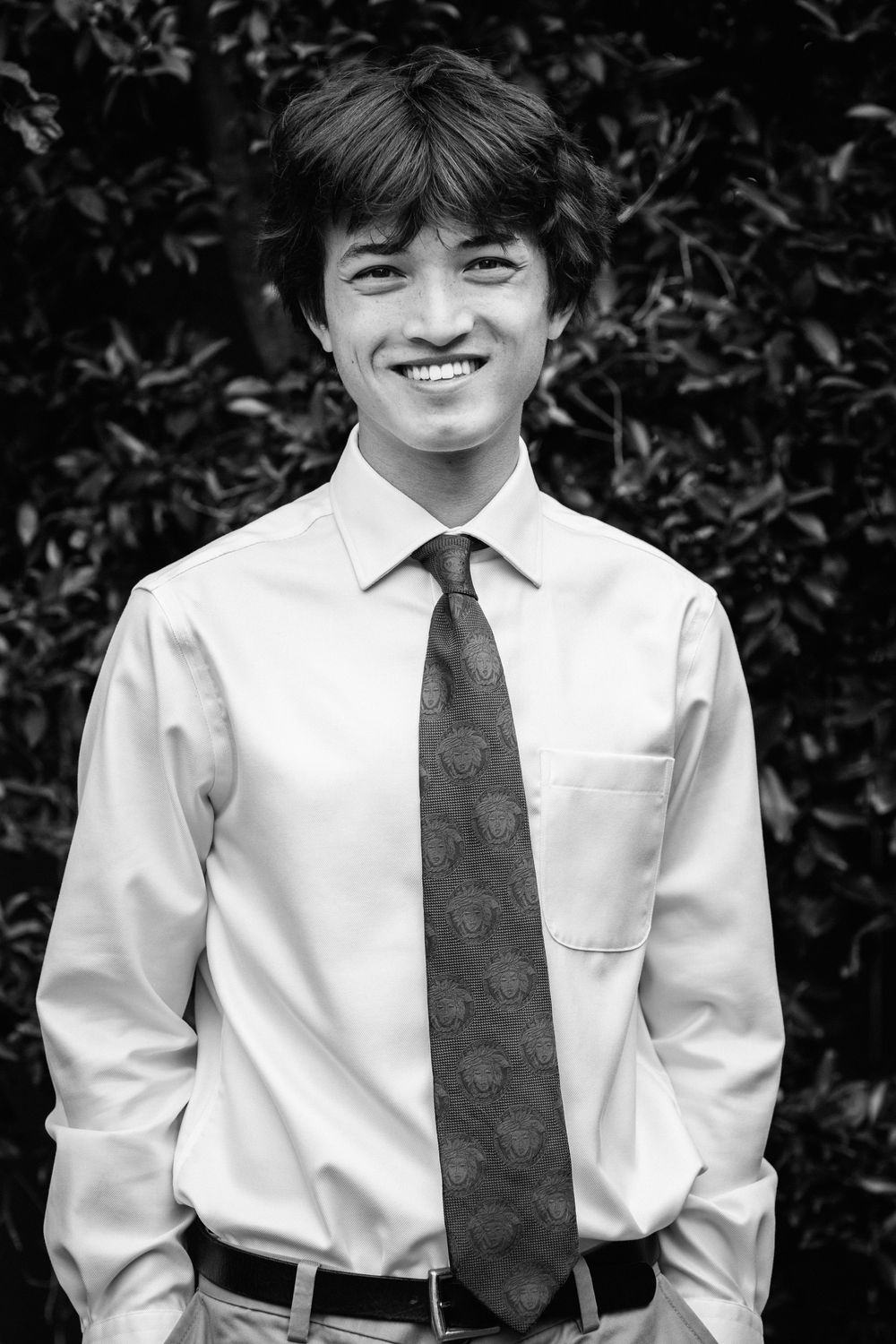 Black and white portrait photograph of someone in professional attire with a white dress shirt and patterned tie.