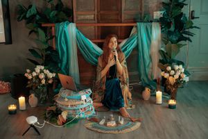 Ethereal studio setup with teal drapes, candles, and floral decorations creating a dreamy atmosphere.