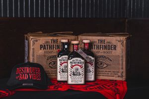 Vintage whiskey boxes and bottles arranged on shelf with red fabric accent.
