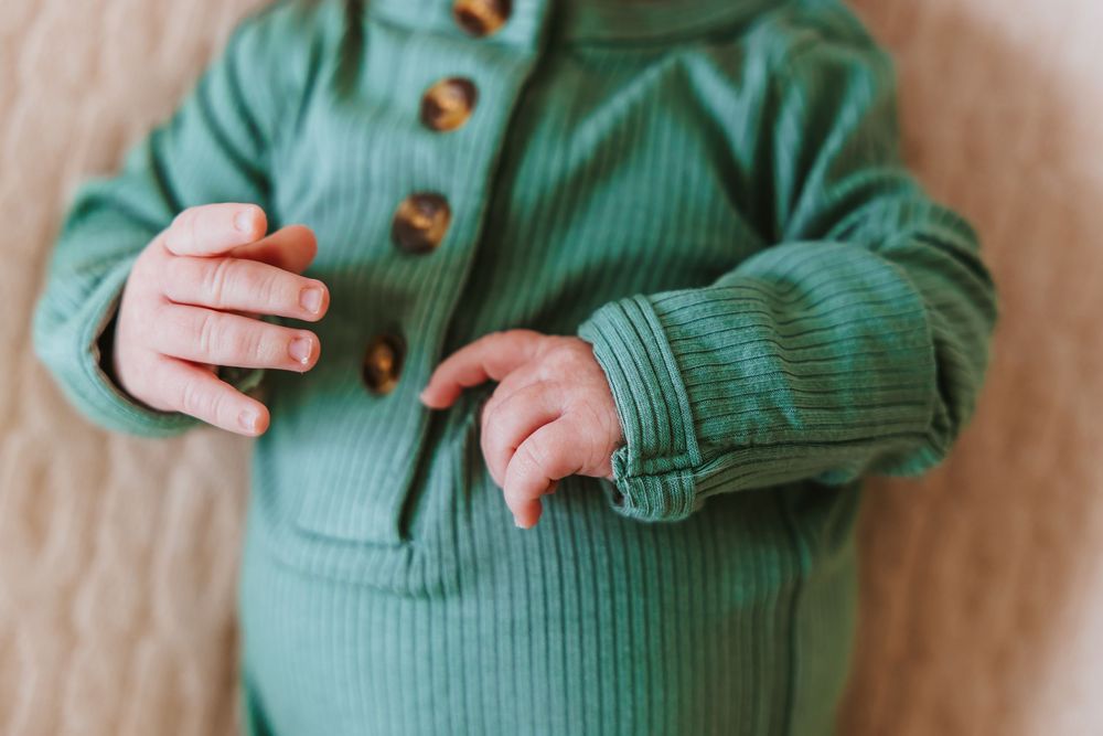 Multiple photos of a baby wearing a sage green ribbed outfit against a neutral background.