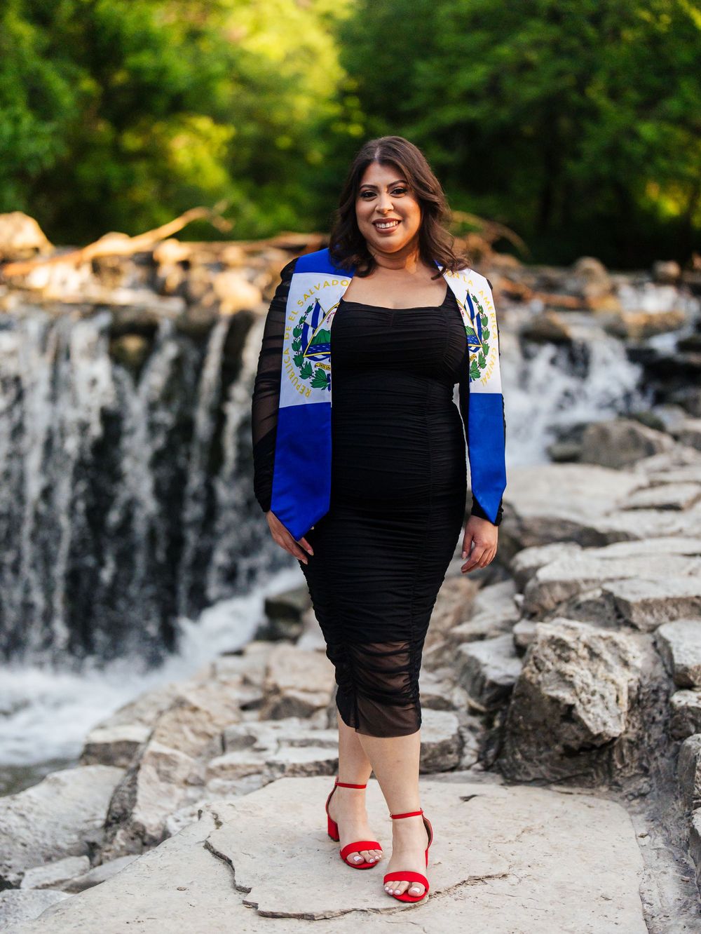 Series of artistic photos showing someone in a black dress and blue blazer posing near a cascading waterfall.
