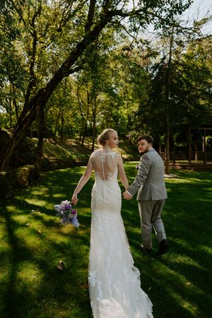 A romantic outdoor wedding photoshoot sequence showing a couple walking through a sunlit wooded area.
