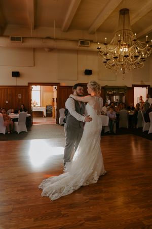 First dance sequence in a reception hall with wooden floors and crystal chandeliers.