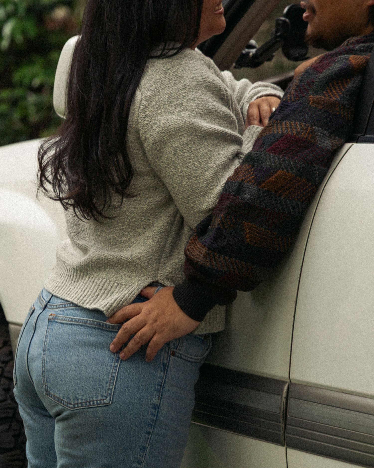 Close-up shot of jeans and sweater details showing casual autumn fashion styling.