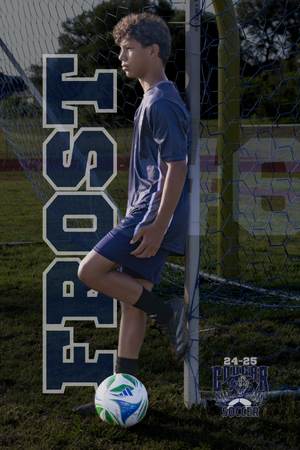 Soccer player with navy blue jersey and shorts poses against goalpost with ball at their feet.