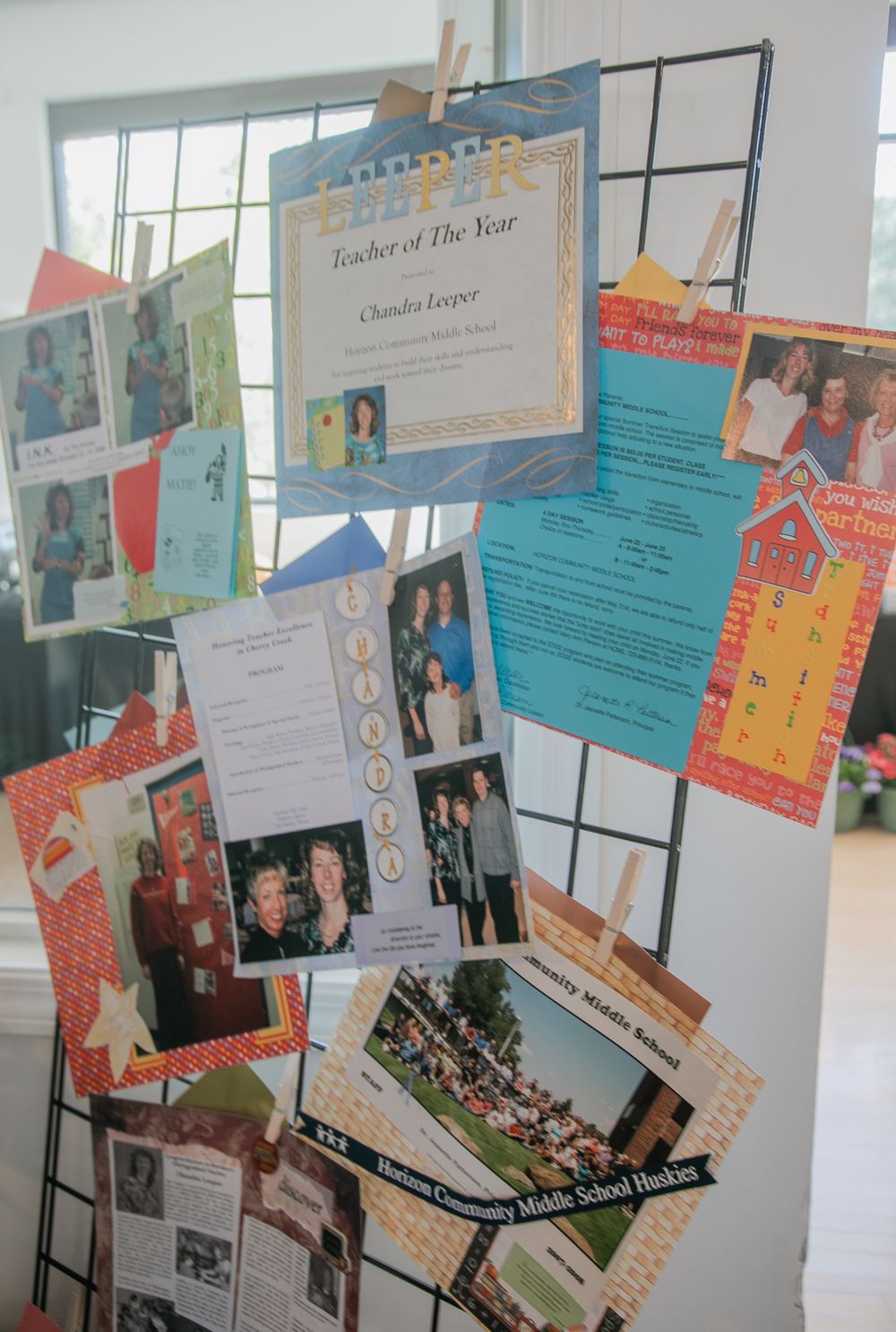 A wall display featuring colorful papers, photographs and writing samples mounted in a classroom or school hallway.