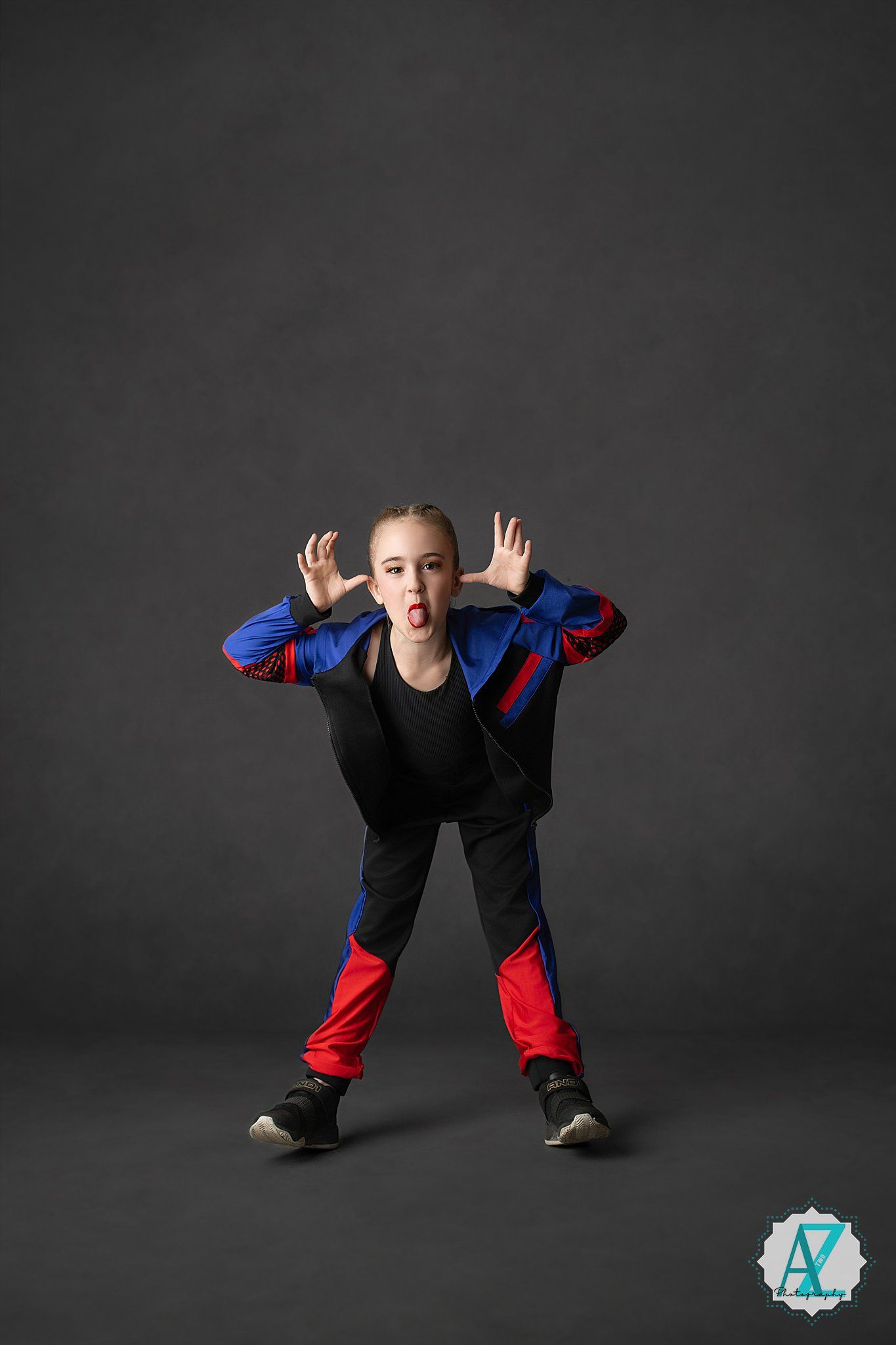 A young dancer in black and red athletic wear strikes dynamic poses against a dark studio background.