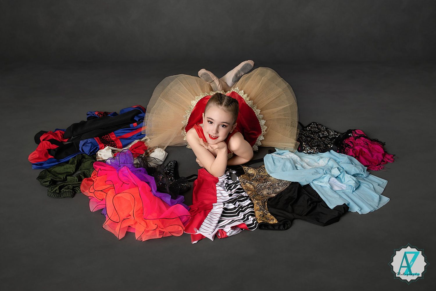 Pile of colorful cheerleading pom poms and dance costumes scattered against dark background.