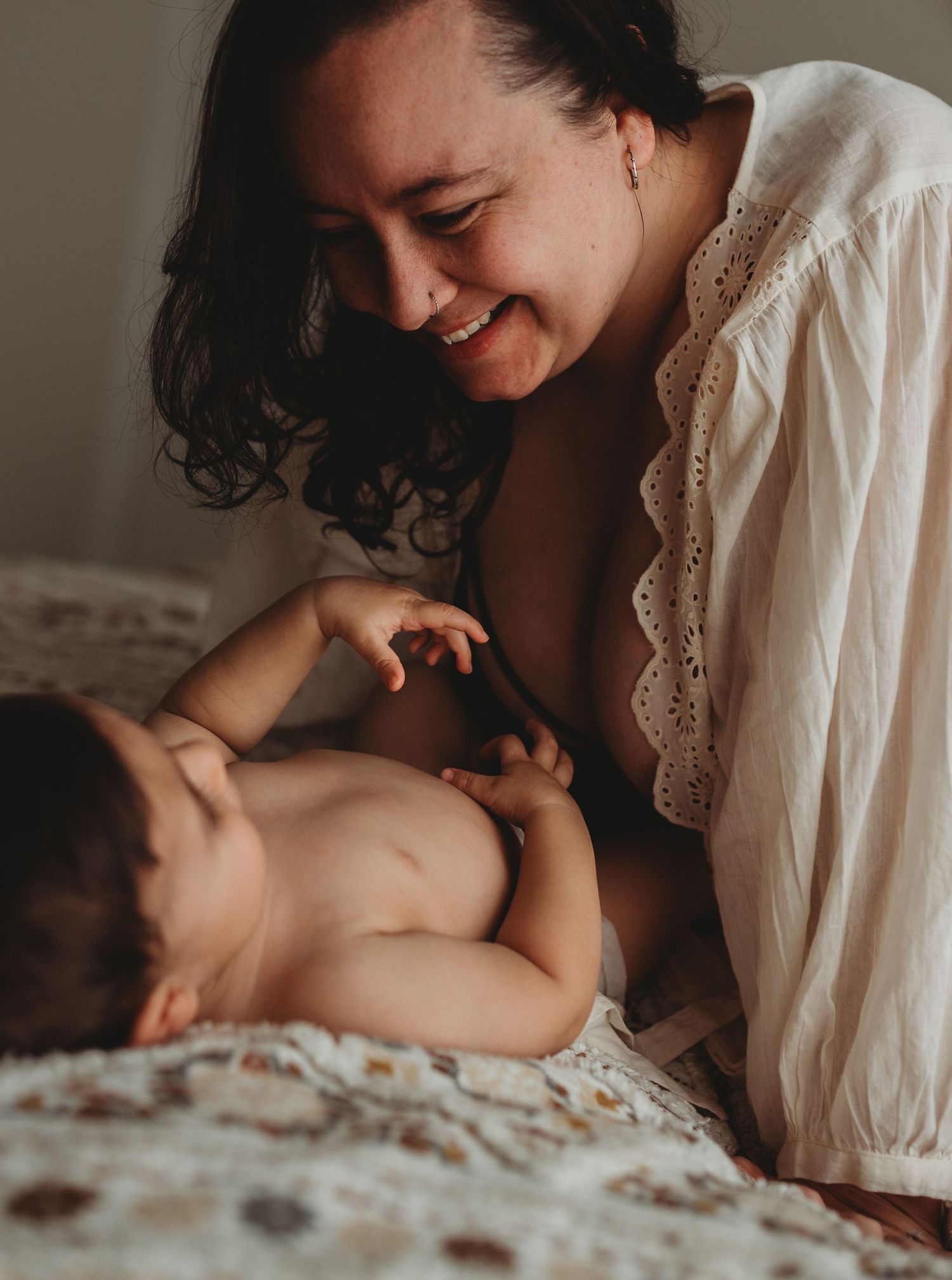 Sweet bonding moment captured on floral bedding in natural light.