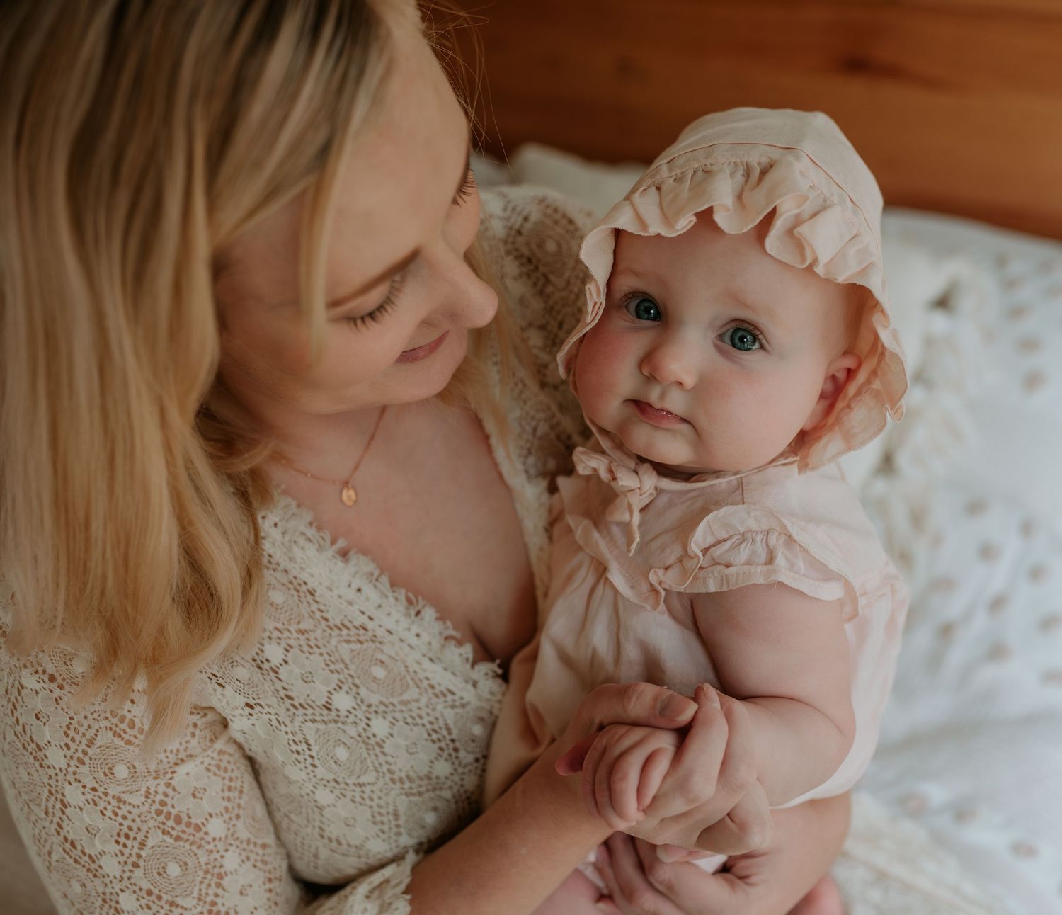 Intimate indoor portrait session with soft lighting and delicate pink tones.