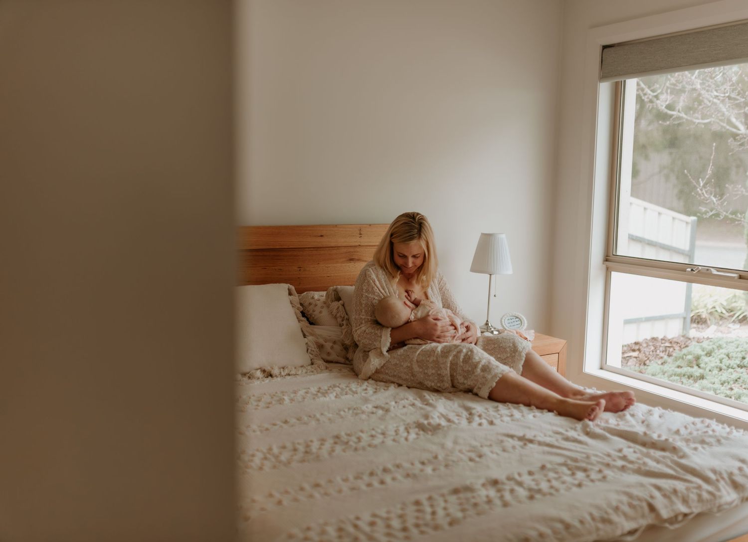 Minimalist bedroom scene with window light and white bedding.