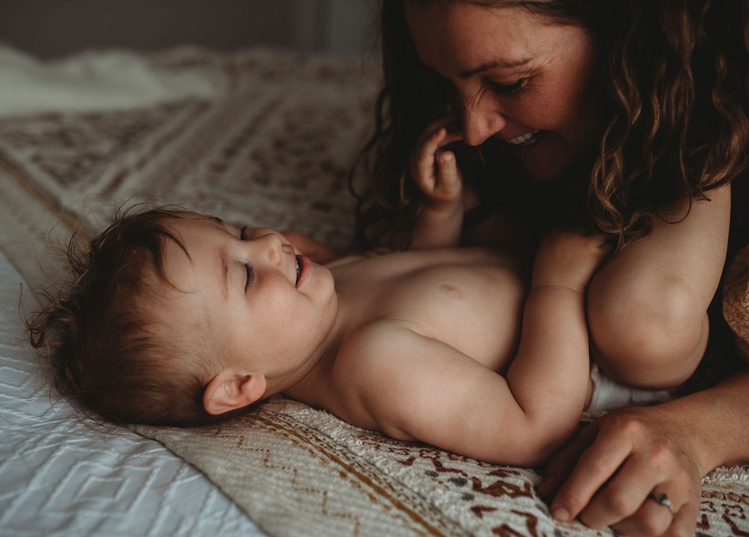 Intimate maternal moment photographed in soft, muted tones.
