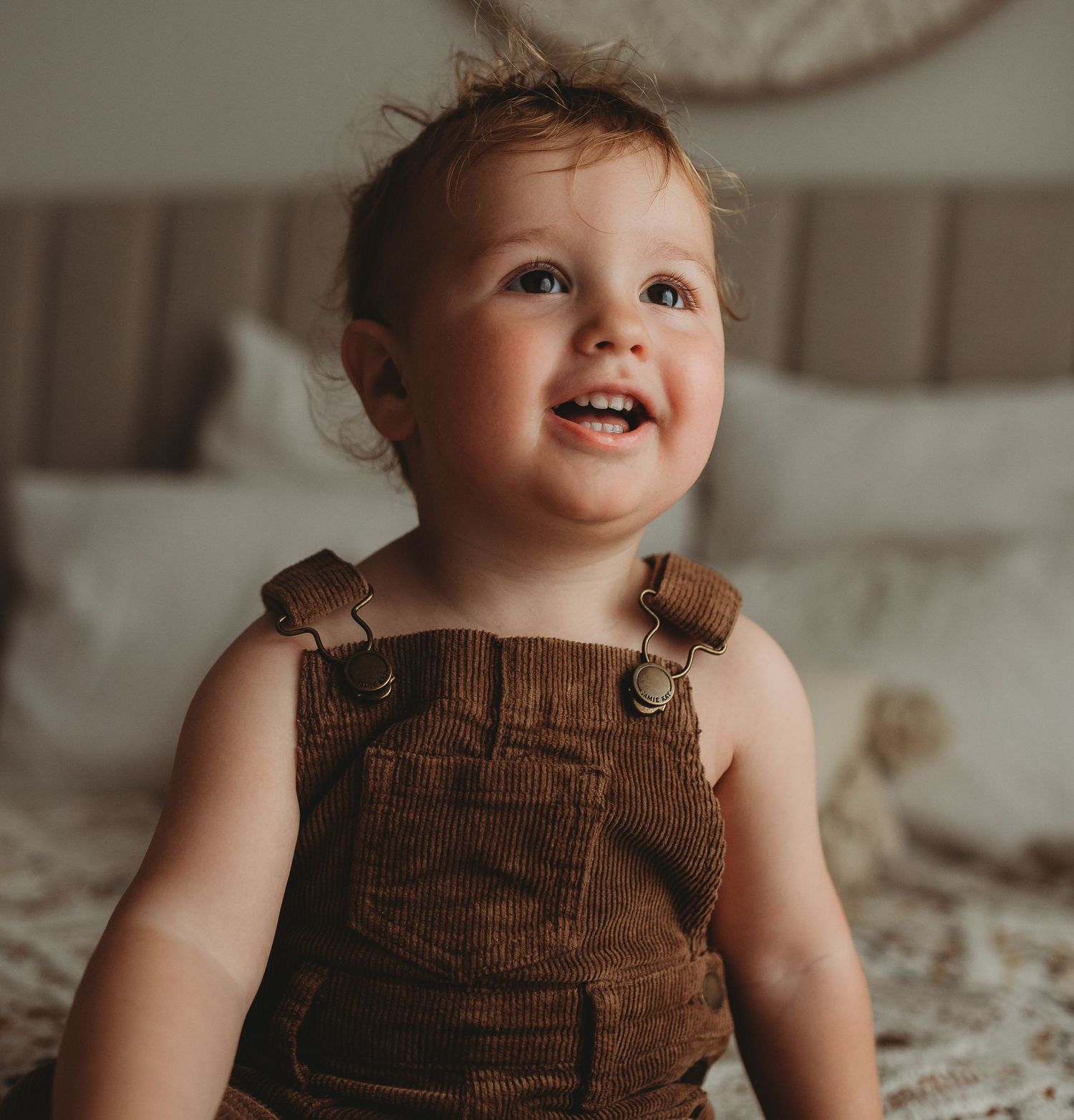 Brown corduroy overalls add rustic charm to this lifestyle portrait session.