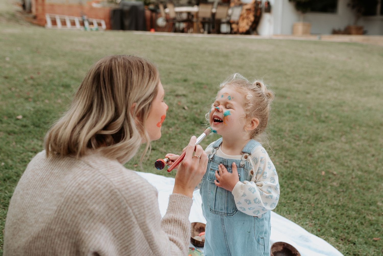 Playful outdoor moment shared on a sunny day with green grass in the background.