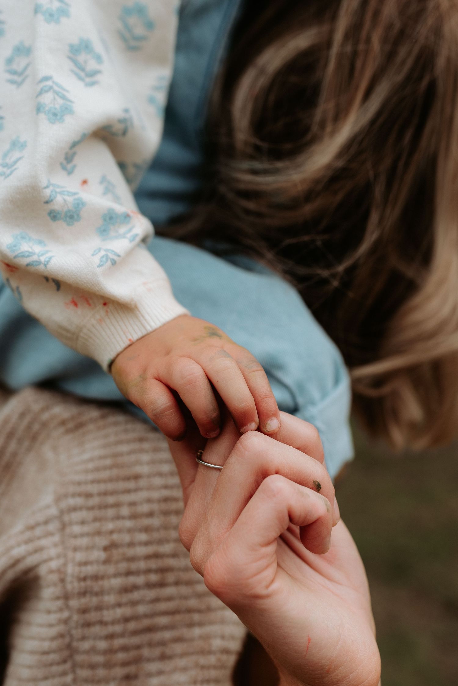 Two hands tenderly clasped together showing a sweet moment of connection and care.