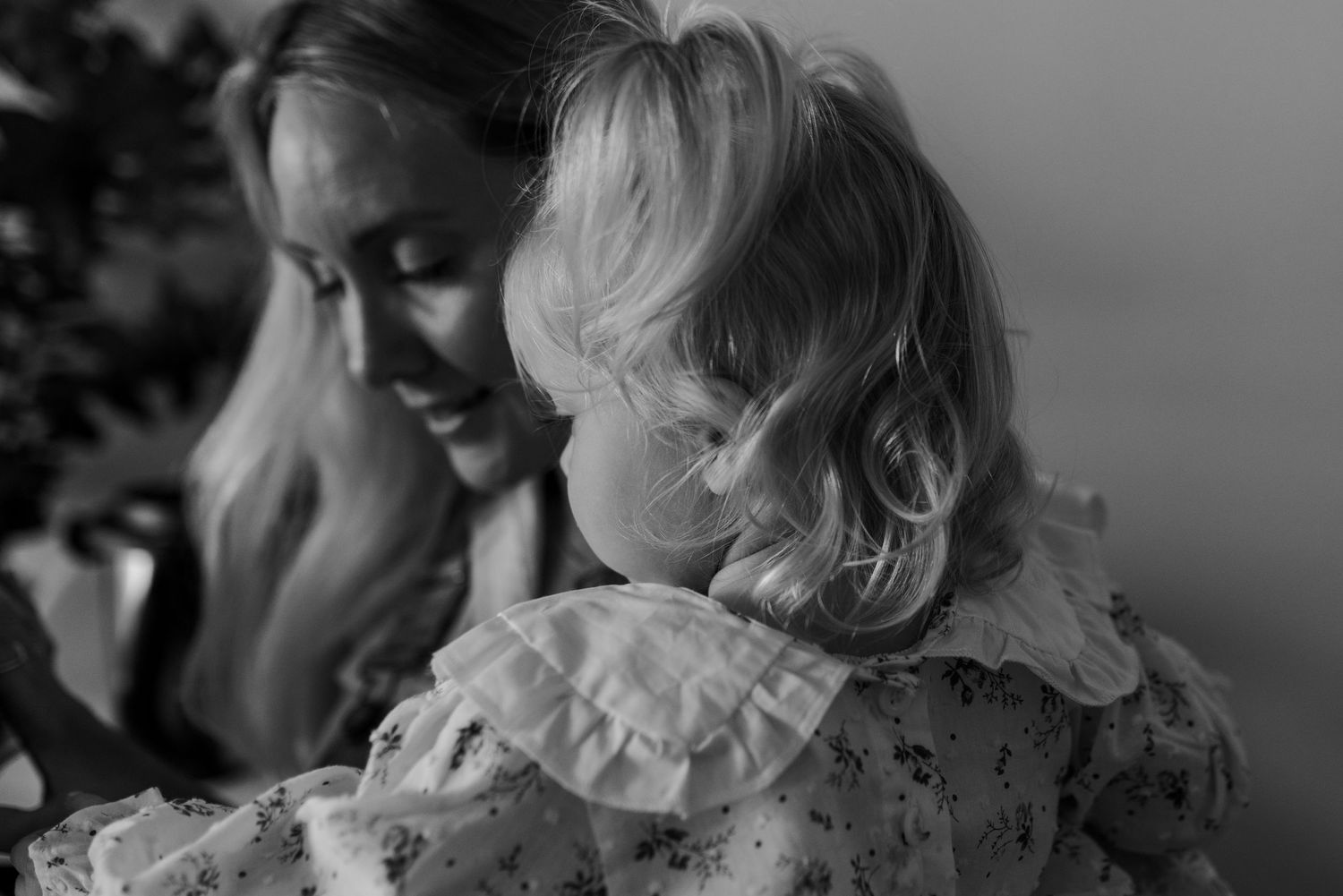A tender black and white portrait showing a gentle embrace in natural light.