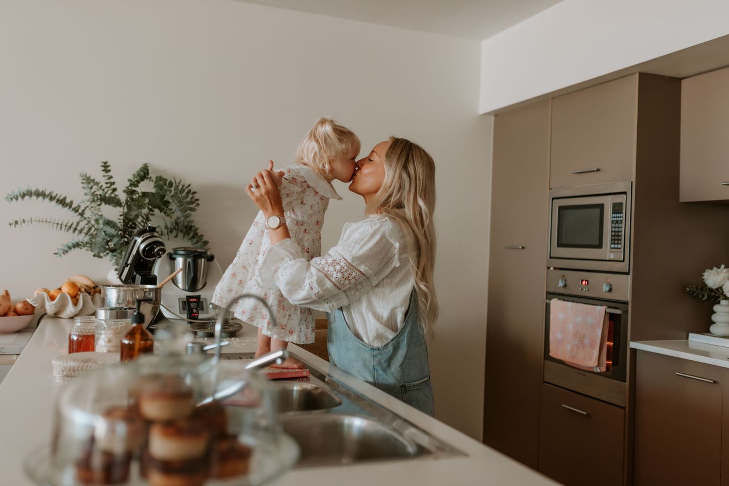 A bright kitchen scene with joyful interaction and baking supplies on the counter.