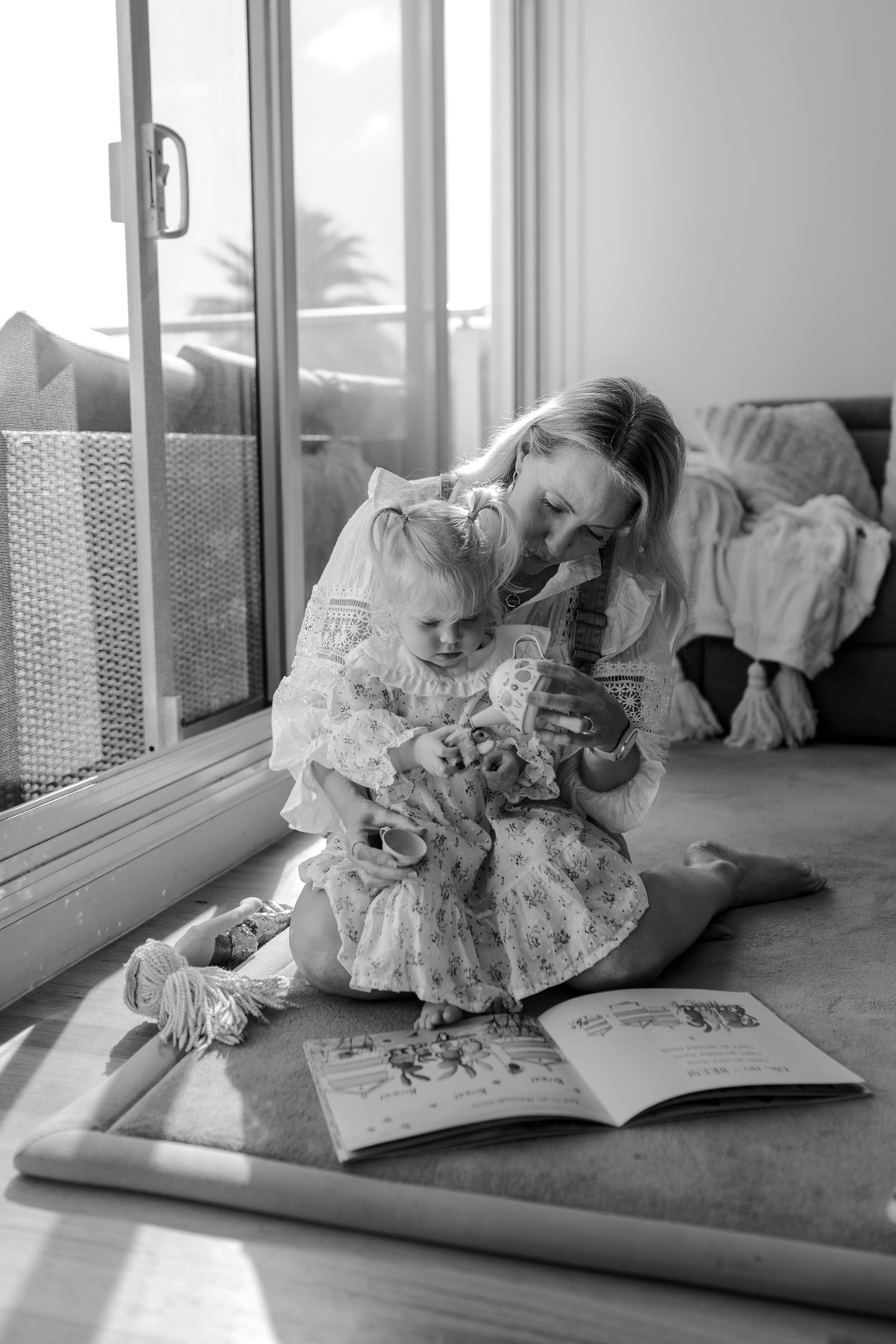 Black and white photo of a reading session by a window.