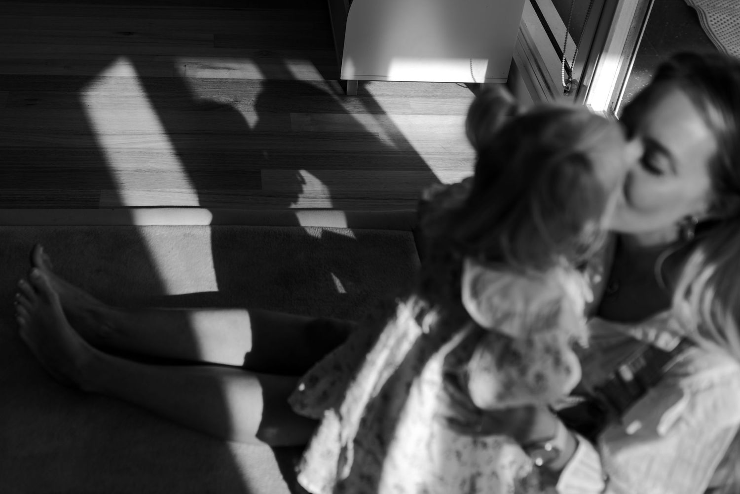 A tender moment captured in dramatic black and white lighting.