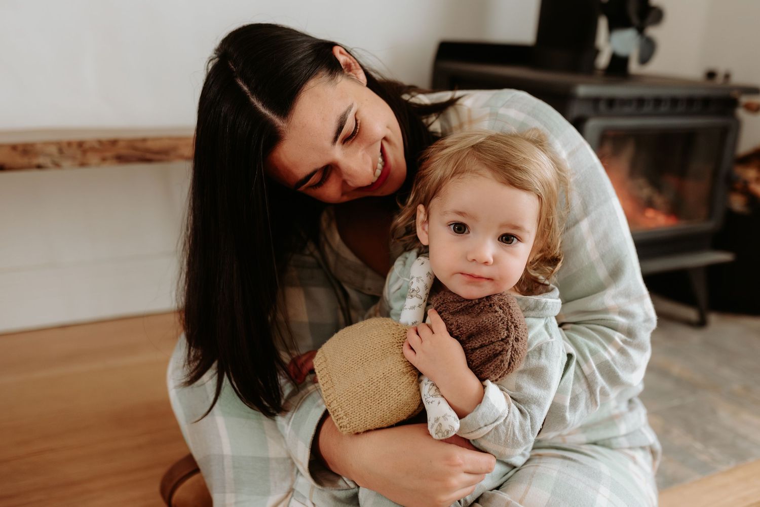 A warm, intimate family moment captured in natural light on a carpeted floor.