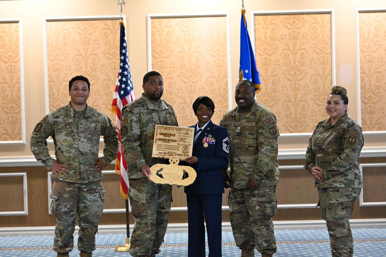 Group of military personnel present ceremonial key during formal event with flags.