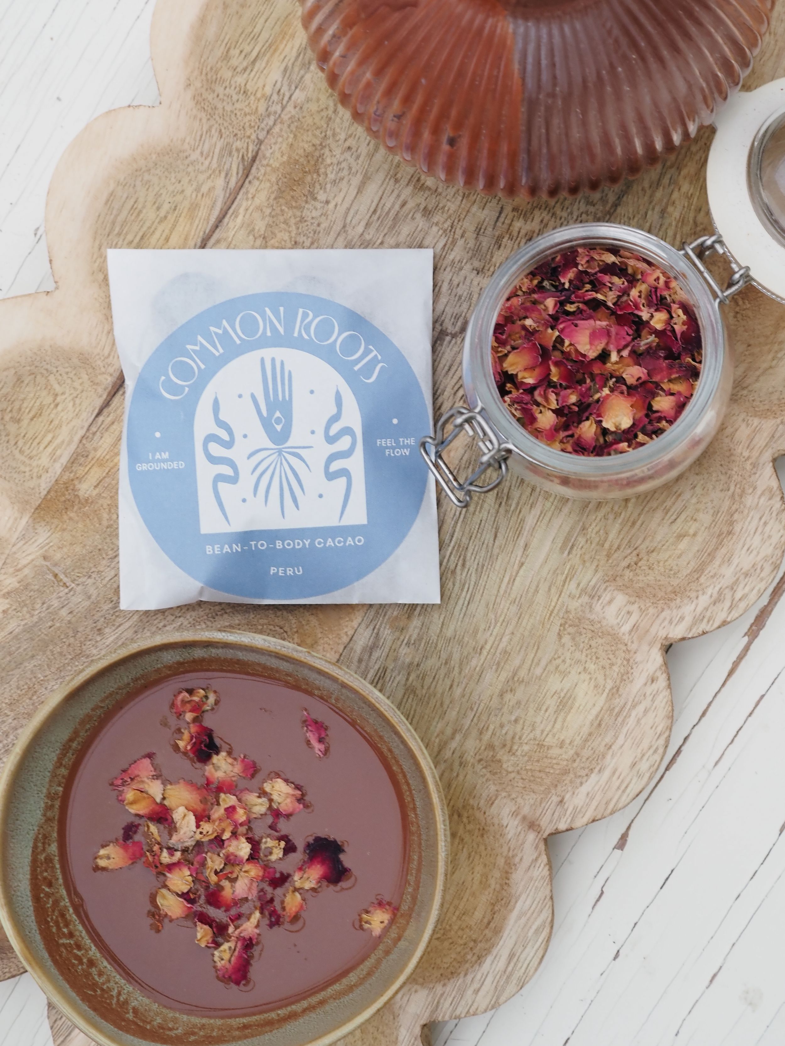 Elegant chocolate dessert plate garnished with dried rose petals and served with Maison Roots branded presentation.
