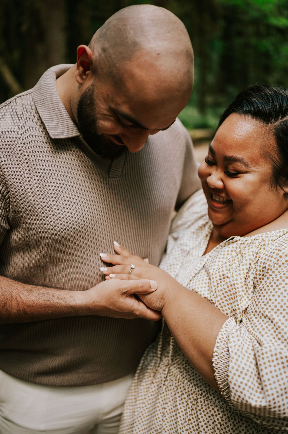 Photo of engaged couple looking at ring in forest Cathedral Groves, MacMillan Park. Vancouver Island adventure photographer